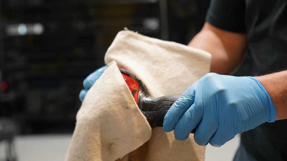 Technician wiping a power tool with a Green Boom pad