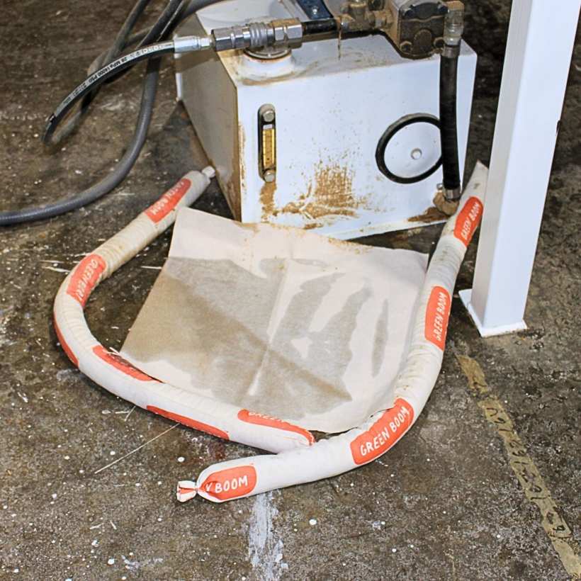 Green Boom socks and pads containing a leak at a pump